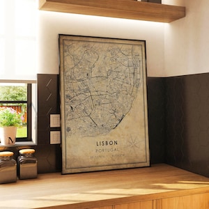 May include: A vintage-style map print of Lisbon, Portugal, with a compass rose and the coordinates 38.7229&deg;N, 9.1393&deg;W. The map is printed on a beige background with black lines and text.