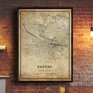 May include: A vintage-style map print of Eugene, Oregon. The map is in black and white with a beige background. The city name and coordinates are printed at the bottom of the map.
