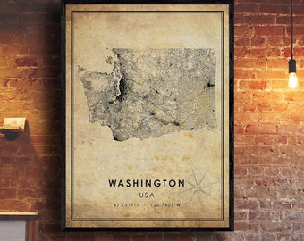 May include: Framed vintage-style map of Washington State, USA, with a black border. The map is in grayscale, showing roads and geographical features. The text "WASHINGTON USA" and coordinates are below the map. A compass rose is in the lower right corner.