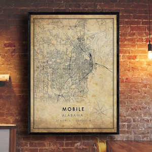 May include: A vintage-style map print of Mobile, Alabama. The map is in black and white with a beige background. The city name and state are printed at the bottom of the map, along with the coordinates 30.6954° N - 88.0399° W.