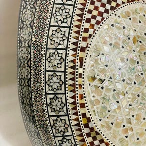 Op de afbeelding: Een witte keramische mok met een zwarte handgreep en de tekst "But First, Coffee" in een vetgedrukte, zwarte letter. De mok staat tegen een vage achtergrond, wat een gezellige setting suggereert.