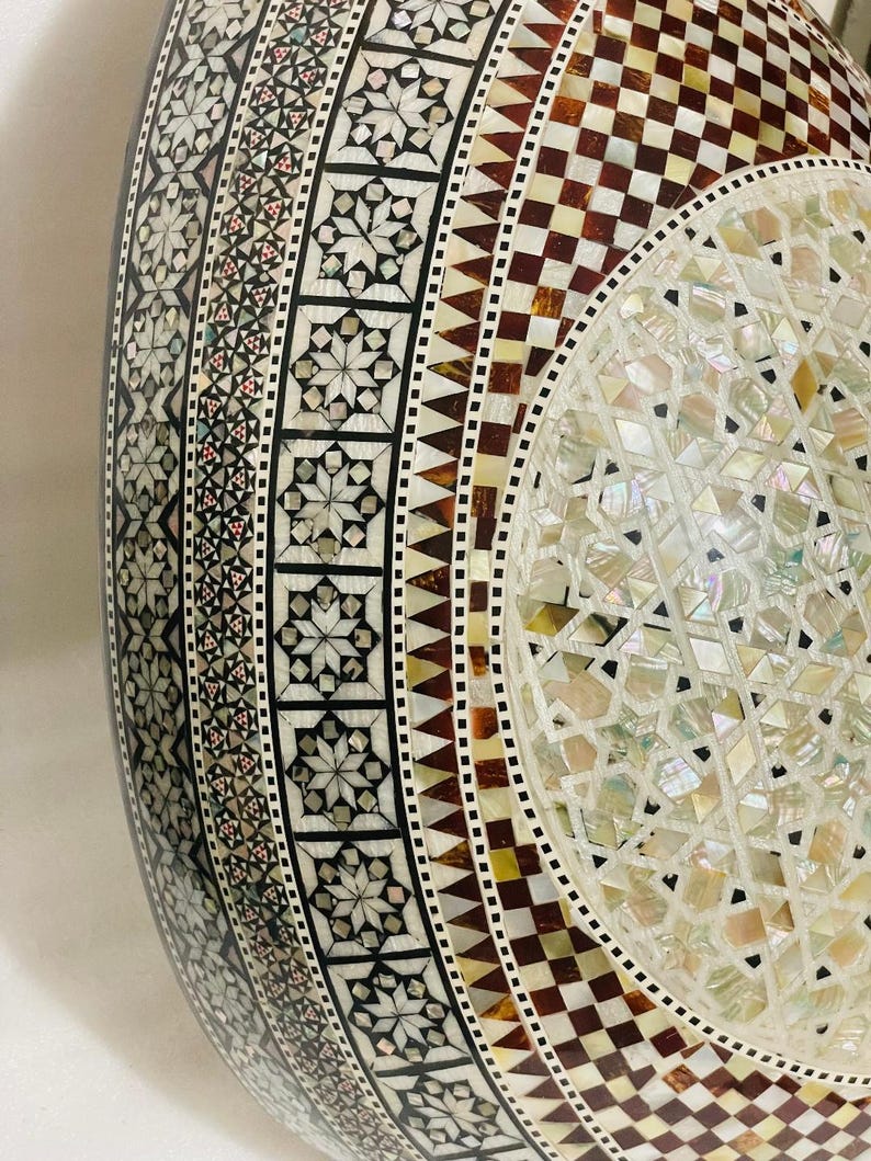 Op de afbeelding: Een witte keramische mok met een zwarte handgreep en de tekst "But First, Coffee" in een vetgedrukte, zwarte letter. De mok staat tegen een vage achtergrond, wat een gezellige setting suggereert.