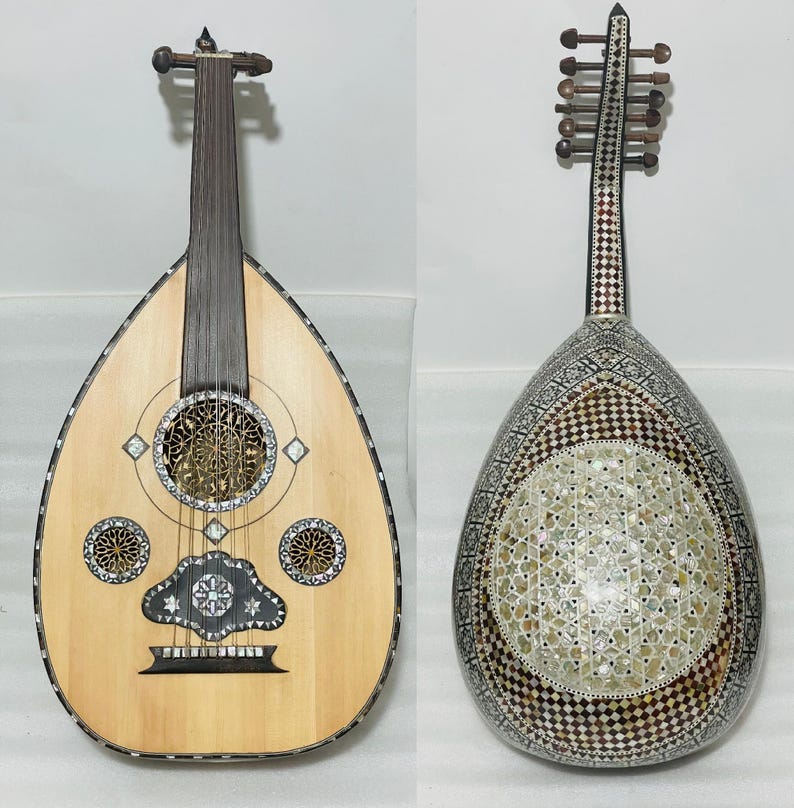 Op de afbeelding: Twee ouds, traditionele snaarinstrumenten uit het Midden-Oosten, worden getoond. E&eacute;n oud heeft een licht houten body met ingewikkeld ingelegd parelmoer en decoratieve klankgaten. De andere oud heeft een donkere, bewerkte body met een vergelijkbaar ontwerp.