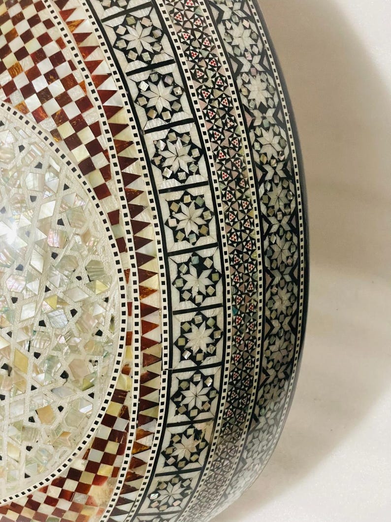 Op de afbeelding: Een handgemaakt houten bord met de tekst "Welkom" in een speels lettertype. Het bord is wit geschilderd met een verweerde afwerking en heeft een bloemenontwerp in roze en groen. Het is ongeveer 30 cm breed.