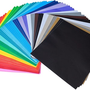 Puede incluir: Un abanico de láminas de vinilo de colores en varios tonos de rosa, rojo, naranja, amarillo, verde, azul, morado y gris. Las láminas están dispuestas en forma de arcoíris con una lámina negra en la parte inferior.