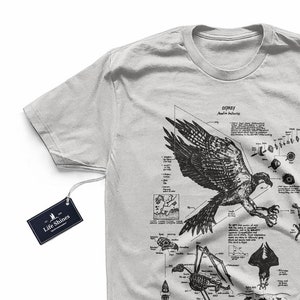 May include: A light grey t-shirt with a black and white illustration of an Osprey. The illustration includes a diagram of the bird's anatomy and flight patterns. The text "OSPREY Pandion haliaetus" is printed above the illustration.