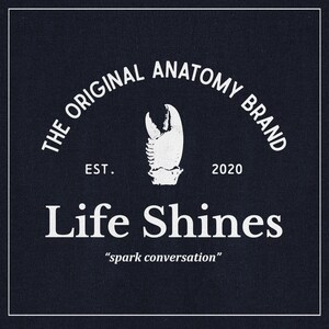 May include: White text on a dark blue background reads "The Original Anatomy Brand Est. 2020 Life Shines "spark conversation"". A white illustration of a lobster claw is centered above the text.