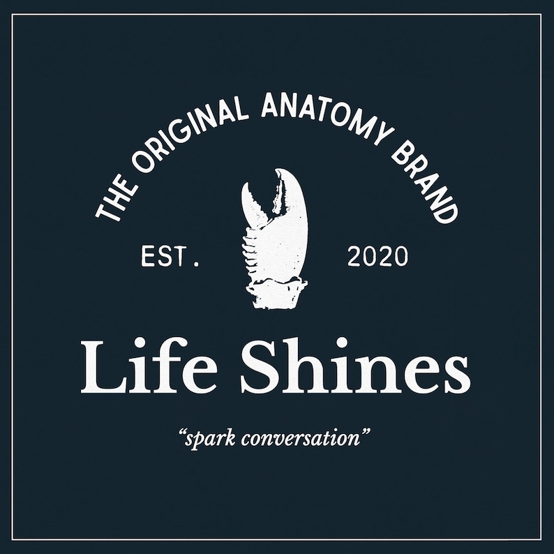 Op de afbeelding: Wit logo op een donkerblauwe achtergrond met de tekst "THE ORIGINAL ANATOMY BRAND EST. 2020 Life Shines "spark conversation""