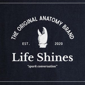 a black shirt with the words life shines printed on it