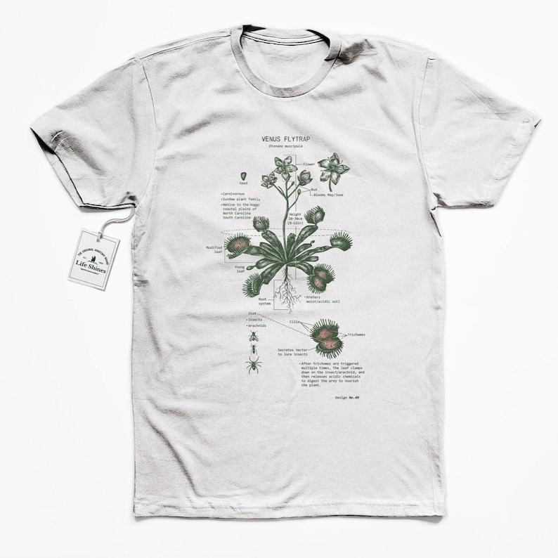 May include: A white t-shirt with a green and brown illustration of a Venus flytrap plant. The illustration includes labels for the different parts of the plant, such as the "trap", "leaves", and "roots". The text "Venus Flytrap" is printed at the top of the illustration.