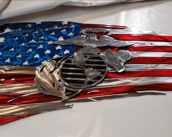May include: A distressed American flag metal wall art with the Marine Corps emblem in the center. The flag is red, white, and blue with a metallic finish.