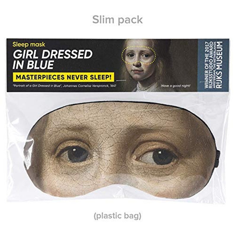 May include: A sleep mask featuring a close-up of a girl's face from the painting "Portrait of a Girl Dressed in Blue" by Johannes Cornelisz Verspronck. The mask is black with a soft, comfortable fabric. The text "Masterpieces Never Sleep!" is printed on the packaging.