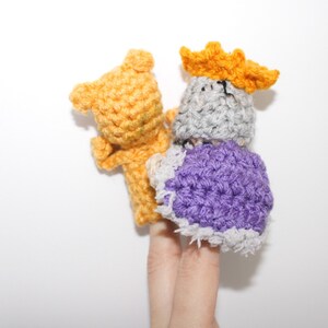 May include: Two finger puppets, one is a yellow bear and the other is a gray king with a purple robe and a yellow crown.