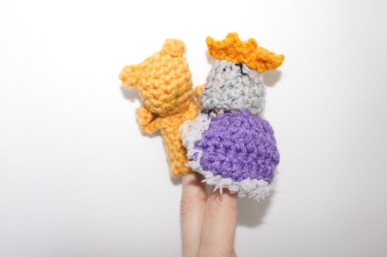 May include: Two finger puppets, one is a yellow bear and the other is a gray king with a purple robe and a yellow crown.