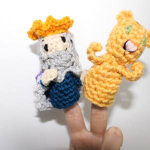 May include: Two finger puppets, one is a king with a yellow crown, gray beard, and blue and gray robe, the other is a yellow bear with green eyes and a pink tongue.