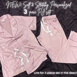 May include: A three-piece pajama set in a soft pink color. The set includes a long-sleeved shirt with a collar, shorts, and long pants. The pajamas are made of a stretchy fabric and are personalized.