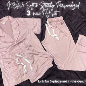 May include: A three-piece pajama set in a soft pink color. The set includes a long-sleeved shirt with a collar, shorts, and long pants. The fabric appears to be soft and stretchy. "NEW! Soft & Stretchy Personalized 3 piece PJ set" is written in white text on a pink background.