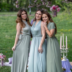 Peut inclure: Trois femmes portant de longues robes enroul&eacute;es vert sauge convertibles. Les femmes sont debout dans une zone herbeuse avec un arbre en arri&egrave;re-plan.