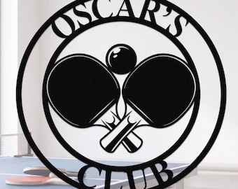 May include: A circular black metal wall sign featuring a graphic of two crossed table tennis paddles and a ball in the center. The text "OSCAR'S" is arched along the top inner border, and the word "CLUB" is arched along the bottom inner border.