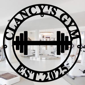 May include: Black metal sign with the text "Clancy's Gym Est 2025" in a circle with a dumbbell in the center.