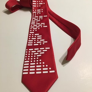May include: A red silk tie with a white pattern of dots and lines. The pattern is a repeating design of dots and lines.
