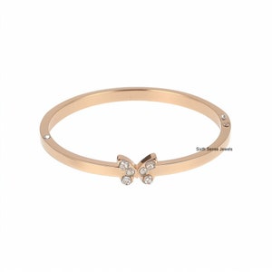 Op de afbeelding: Een roségouden armband met een vlinderbedel versierd met heldere strass steentjes. De armband is gemaakt van roestvrij staal en heeft een eenvoudig, elegant ontwerp.