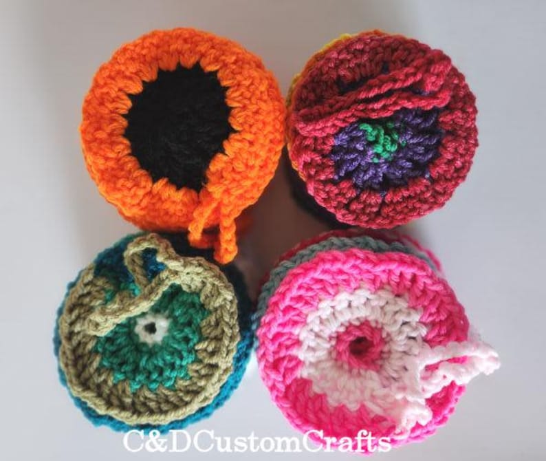 Pu&ograve; includere: Quattro sottobicchieri rotondi all'uncinetto con diversi motivi colorati. I sottobicchieri sono realizzati con una variet&agrave; di colori, tra cui arancione, rosso, rosa, verde e bianco.