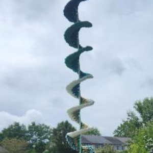 Pu&ograve; includere: Una decorazione a spirale in crochet appesa con uno schema di colori bianco e verde acqua. La decorazione &egrave; appesa a un soffitto ed &egrave; realizzata con filato.