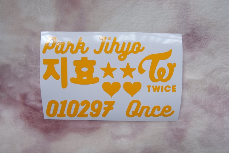 May include: A white sticker sheet with orange text and graphics. The text includes "Park Jihyo", Korean characters, stars, hearts, the word "TWICE", the numbers "010297", and the word "Once".
