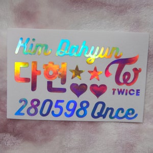 May include: A holographic sticker with the name "Kim Dahyun" and Korean characters, along with the word "TWICE" and the number "280598 Once". The sticker features stars and hearts.