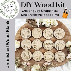 May include: DIY wood kit with unfinished wood blanks. The kit includes twelve round wooden pieces, each engraved with a month and a corresponding design. The image also features text that reads "Creating Joy & happiness One Brushstroke at a Time."