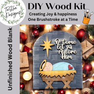 May include: DIY wood kit with a nativity scene design. The kit includes an unfinished wood blank with a star, baby Jesus in a manger, and the words "O Come let us Adore Him". The kit is from Tasha Designs.