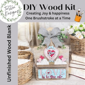 May include: DIY wood craft kit featuring a hot air balloon with a heart that says "Love" and a sign that says "Love is in the air". The kit includes unfinished wood pieces, a bow, and hearts.
