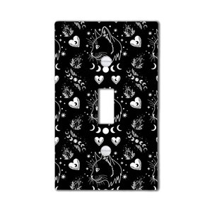 May include: Black and white light switch cover with a repeating pattern of cats, hearts, moons, and stars.