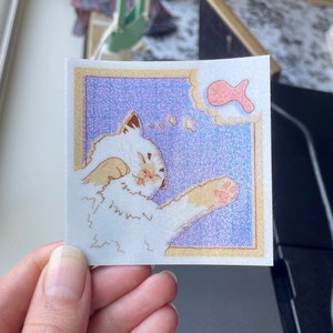 Puede incluir: Un gato blanco con orejas rosas y una nariz rosa se está lamiendo la pata. El gato está soñando con un pez rosa. El fondo es azul claro con un patrón blanco moteado.
