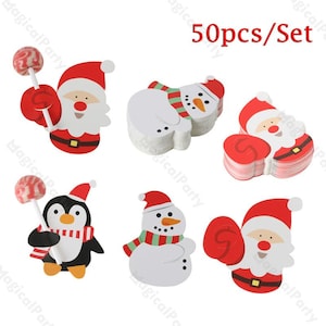 May include: Christmas-themed paper cutouts featuring Santa Claus, snowmen, and a penguin, each with a lollipop. The cutouts are red, white, black, and yellow. The text "50pcs/Set" is visible.