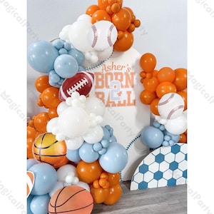 Könnte beinhalten: Eine Sport-Themen-Ballonbogen mit orangefarbenen, weißen und blauen Luftballons. Der Bogen enthält Baseball-, Football- und Basketball-Ballondekorationen. Ein Schild liest "Asher's Born to Ball".