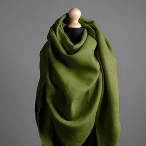 Może przedstawiać: Zielony szal z lnu drapowany na manekinie. Szal wykonany jest z miękkiej, naturalnej tkaniny i ma prosty, elegancki design.
