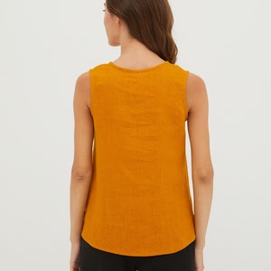 May include: A sleeveless, mustard yellow, linen top with a scoop neck.