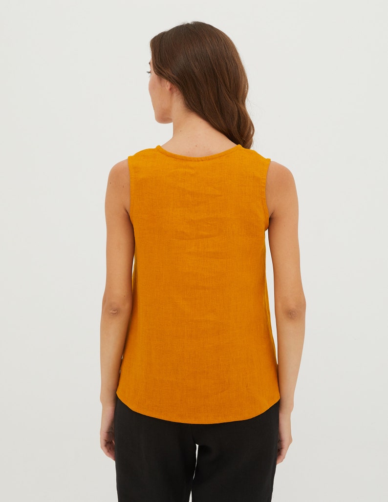 May include: A sleeveless, mustard yellow, linen top with a scoop neck.