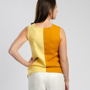 May include: A sleeveless top with a yellow and orange color block design. The top is made of a linen fabric and has a relaxed fit.