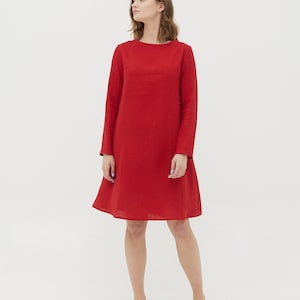 May include: A red linen dress with long sleeves and a slightly flared skirt.