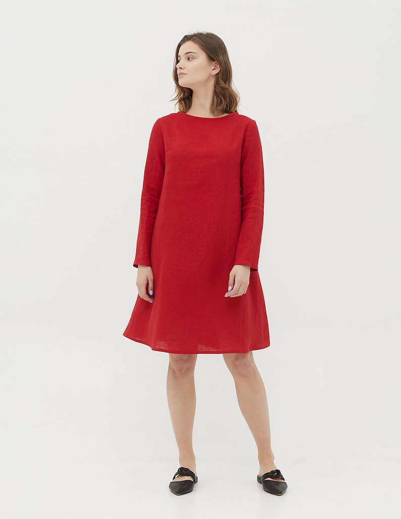 May include: A red linen dress with long sleeves and a slightly flared skirt.