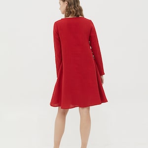 May include: A red linen dress with long sleeves and a slightly flared skirt.