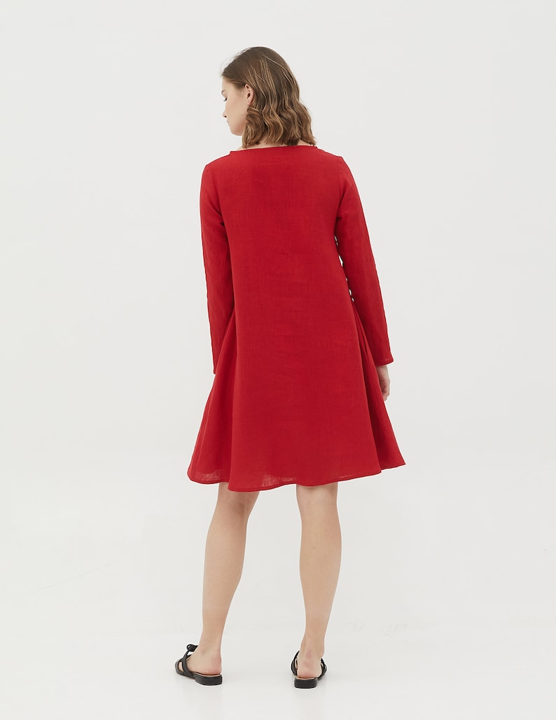 May include: A red linen dress with long sleeves and a slightly flared skirt.