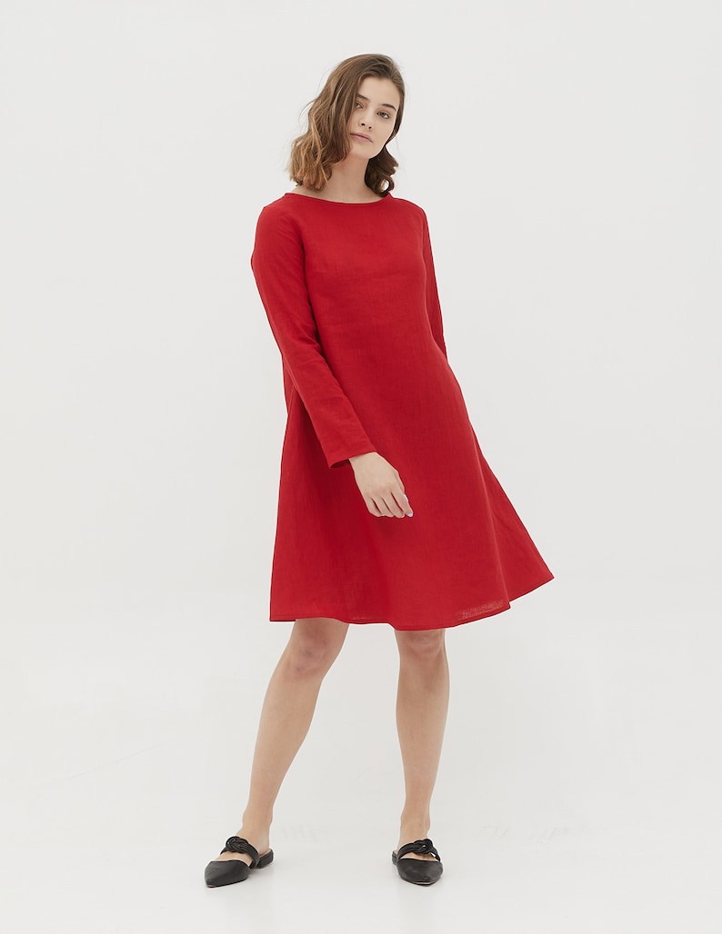 May include: A red linen dress with long sleeves and a slightly flared skirt.