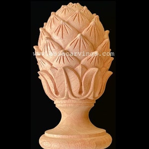 May include: A wooden finial with a carved pineapple design. The finial is a light brown color and has a smooth finish. It is a decorative element that can be used on furniture, cabinets, or other objects.