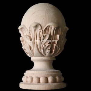 May include: A wooden finial with a round top and a base with a beaded edge. The top is carved with a floral design. The finial is unpainted and has a natural wood finish.