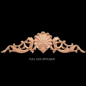 May include: A wooden carved applique with a shell design in the center and intricate scrollwork on either side. The applique is unfinished and ready to be painted or stained. "Full Size Applique" is written below the applique.