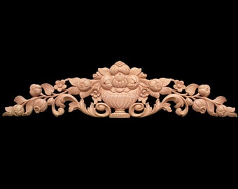 May include: A carved wooden decorative piece with a floral design. The piece features a vase with flowers and leaves, and is made of light brown wood.